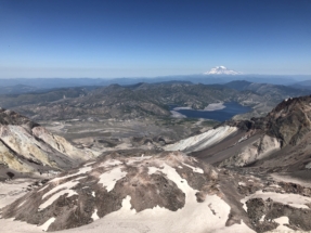 Peering into the crater at the summit after climbing Mount Saint Helens. Spirit lake and Mount Rainier in the distance.